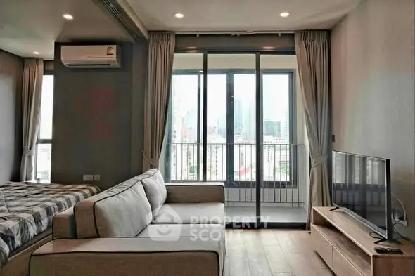 Modern living room with city view, featuring a cozy sofa and large windows for natural light.
