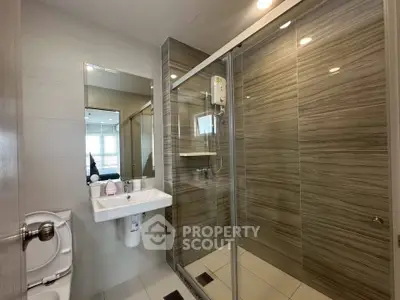 Modern bathroom with sleek shower and stylish tiles in contemporary apartment.
