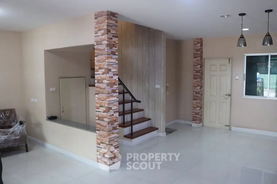 Modern interior with stylish staircase and stone accents in a spacious living area.