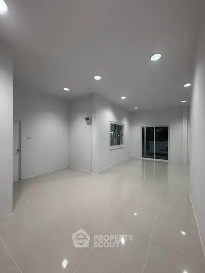 Spacious modern living room with recessed lighting and large windows