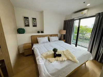 Cozy bedroom with balcony view, featuring modern decor and natural light.
