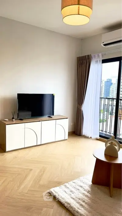 Modern living room with city view, featuring sleek TV stand and cozy decor.