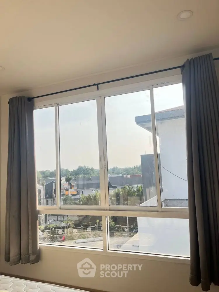 Bright window view from a modern bedroom with curtains and scenic outdoors.