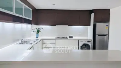 Modern kitchen with sleek cabinetry, stainless steel appliances, and a washing machine for convenient living.