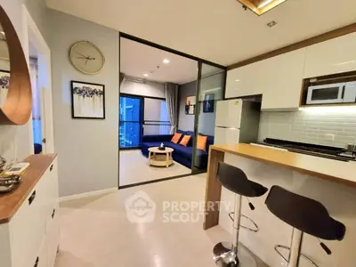 Modern open-plan kitchen and living room with stylish decor and sleek furniture.