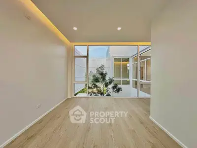 Spacious modern room with large windows and wooden flooring