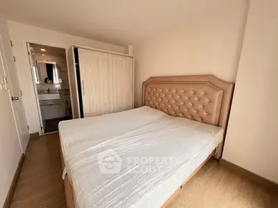 Spacious bedroom with elegant headboard and ensuite bathroom, perfect for modern living.
