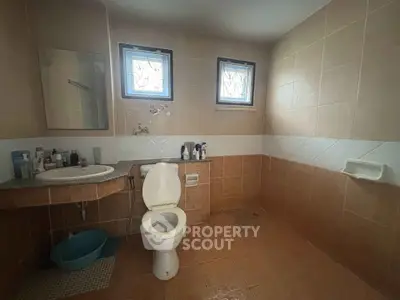 Spacious bathroom with modern fixtures and natural light from two windows.