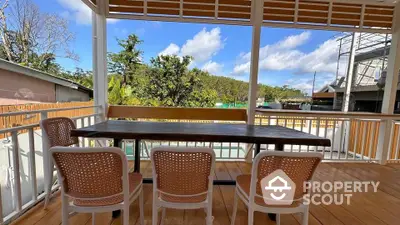 Charming outdoor balcony with wooden deck and seating, perfect for relaxation.