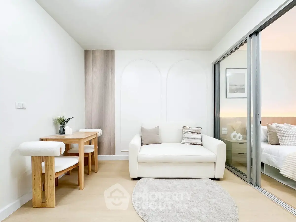 Modern living room with cozy white sofa and dining area, featuring elegant decor and natural light.