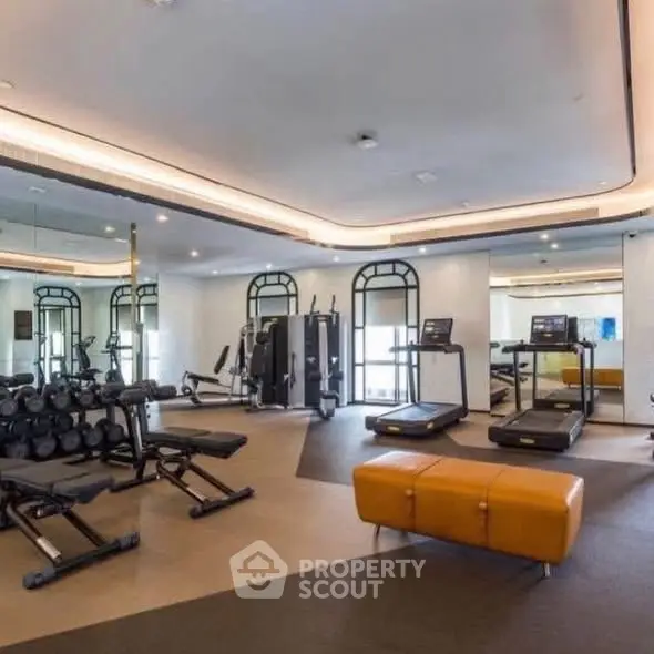 Luxurious gym with modern equipment and stylish design in upscale residential building.