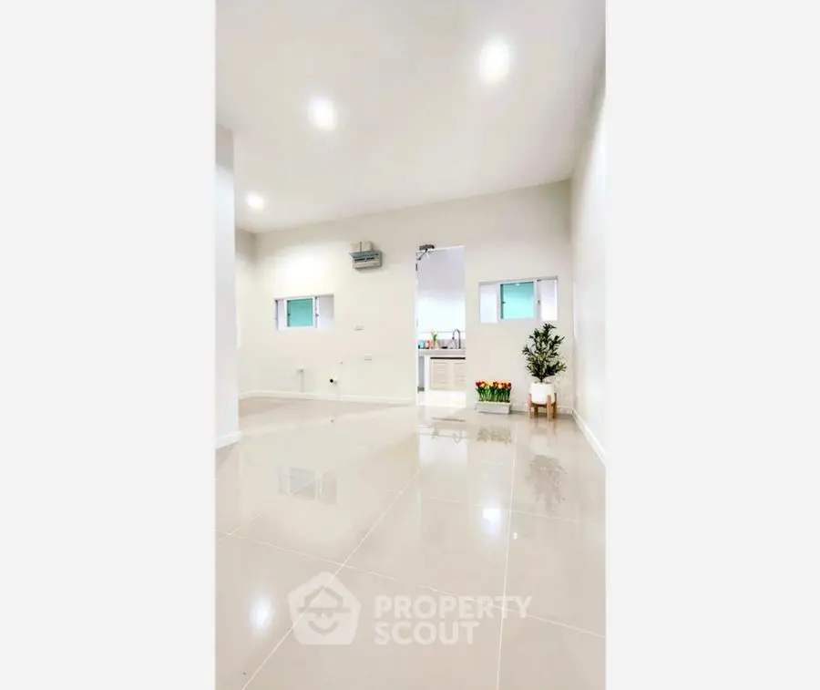 Spacious modern interior with glossy tiled floors and minimalist decor.