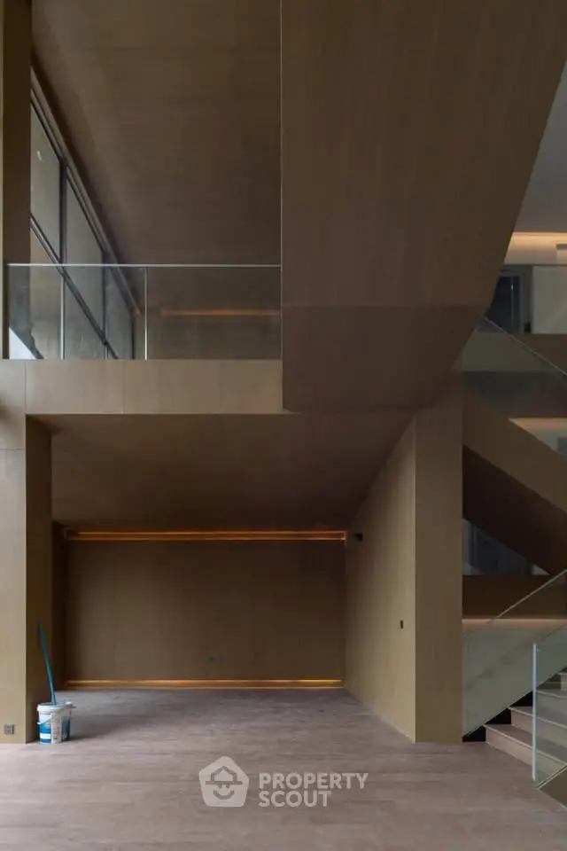 Modern architectural interior with wooden finishes and glass railings, showcasing minimalist design.