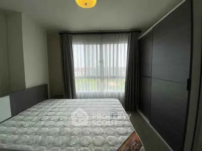 Cozy bedroom with large window and modern wardrobe, perfect for relaxation.