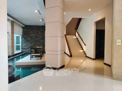 Luxurious modern interior with elegant staircase and stylish decor in a spacious living area.