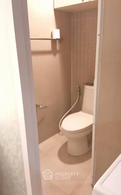 Compact bathroom with modern toilet and beige tiles, ideal for small apartments.