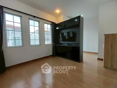 Spacious living room with large windows and modern TV setup