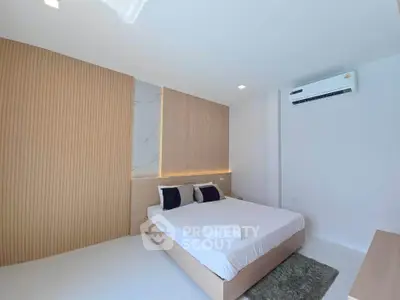 Modern minimalist bedroom with stylish wood paneling and air conditioning