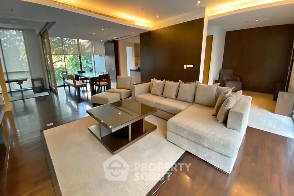 Spacious modern living room with elegant furniture and large windows offering a serene view.
