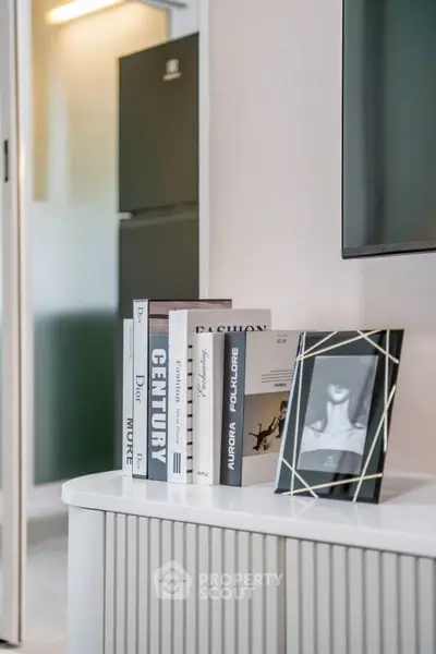 Stylish modern interior with decorative books and framed photo on a sleek console table.