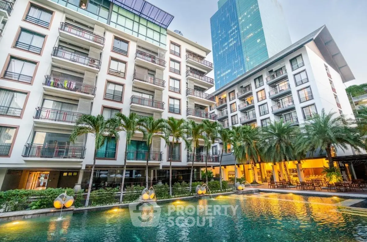 Luxurious modern apartment complex with stunning pool and lush palm trees
