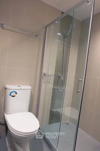 Modern bathroom with glass shower enclosure and sleek toilet design.