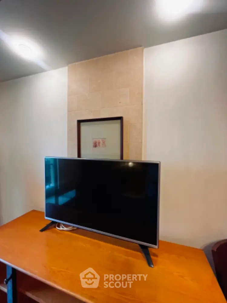 Modern living room with sleek TV setup on wooden table, perfect for entertainment.