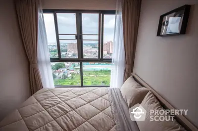 Cozy bedroom with panoramic city view through large window, featuring elegant curtains and modern decor.