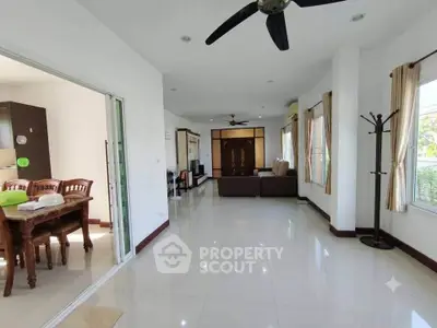 Spacious living room with elegant dining area and large windows
