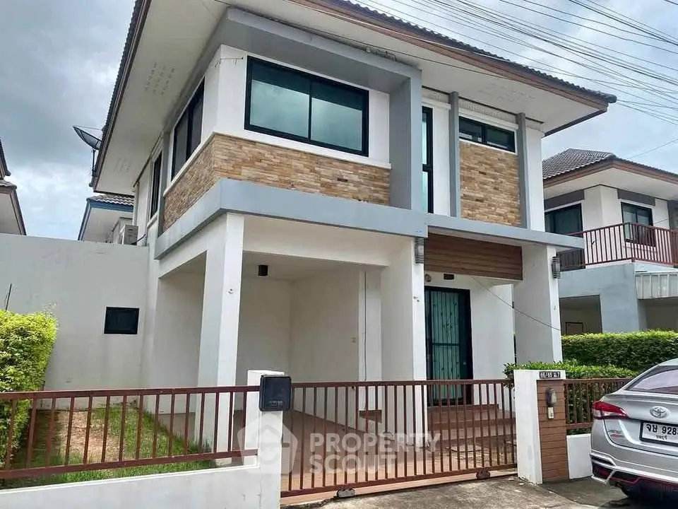 Modern two-story house with brick accents and spacious driveway in a suburban neighborhood.