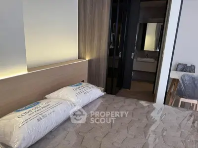 Modern bedroom with stylish decor and ensuite bathroom in a contemporary apartment.