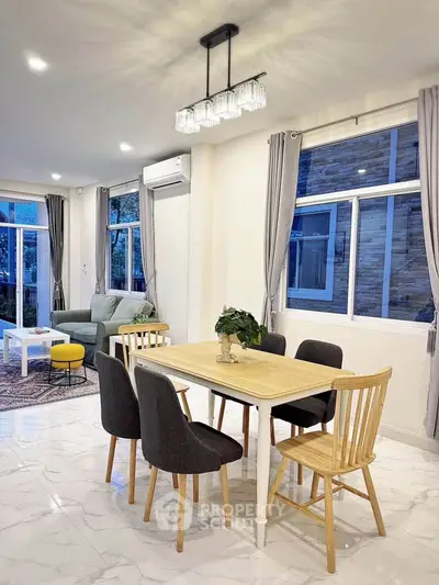 Modern dining area with elegant lighting and stylish furniture in a bright, airy living space.