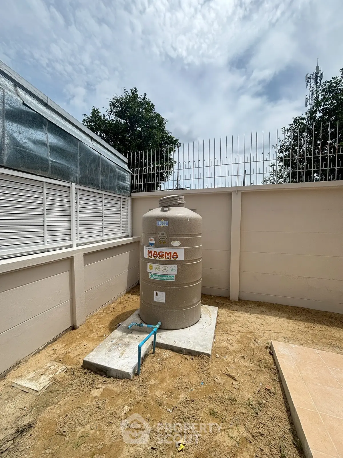 Outdoor water tank in a secure fenced area with clear sky