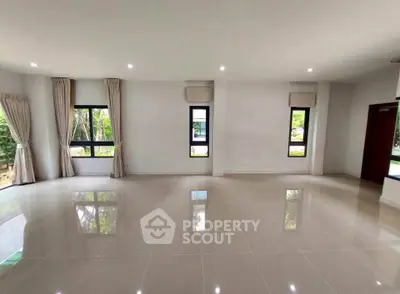 Spacious empty living room with large windows and tiled flooring