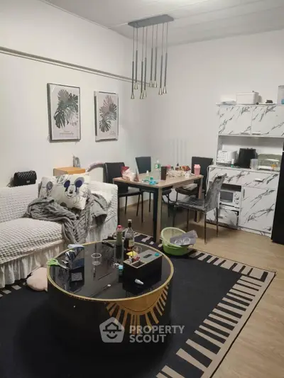 Stylish living room with modern decor and open layout, featuring chic furniture and elegant lighting.
