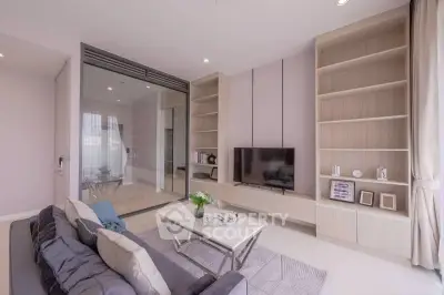 Modern living room with sleek design, large TV, and stylish shelving in a bright apartment.