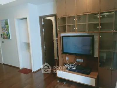 Modern living room with wooden flooring and built-in TV cabinet in a stylish apartment.