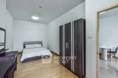 Spacious bedroom with modern furniture and wooden flooring