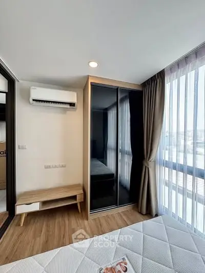 Modern bedroom with large windows and sleek wardrobe in a stylish apartment.