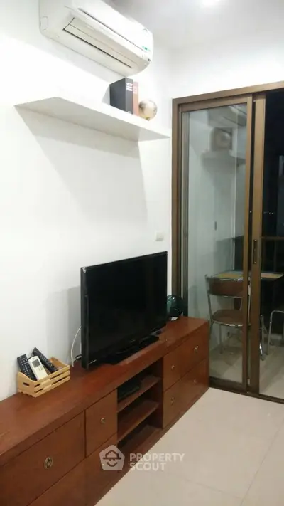 Modern living room with air conditioning and sliding glass door to balcony