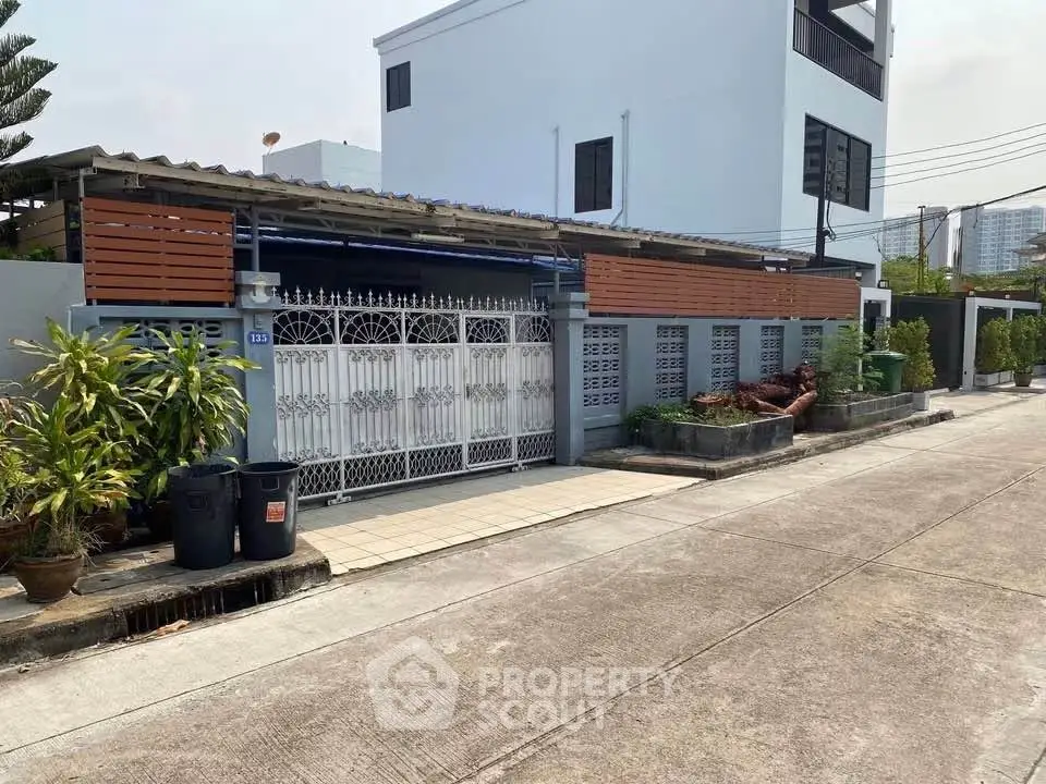 Charming residential property with gated entrance and modern exterior design in a serene neighborhood.