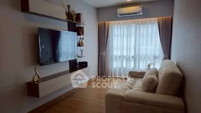 Modern living room with sleek TV setup and cozy sofa, featuring elegant decor and natural light.