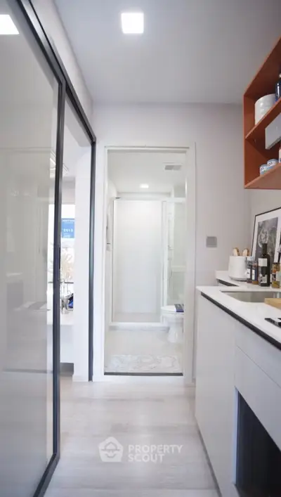 Modern kitchen with sleek design and view into a compact bathroom