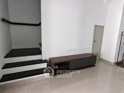 Modern minimalist interior with sleek staircase and stylish console table.