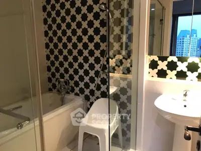 Stylish bathroom with modern black and white tile design and city view window.