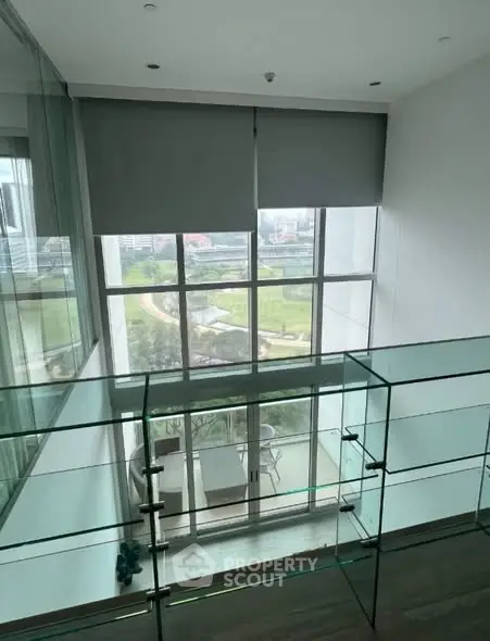 Stunning two-story glass-walled living space with panoramic city views and modern design.