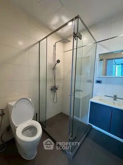 Modern bathroom with glass shower enclosure and sleek fixtures