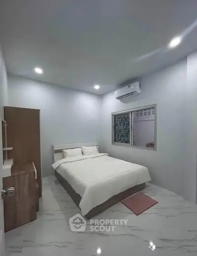 Modern bedroom with sleek design, featuring a comfortable bed, air conditioning, and minimalist decor.