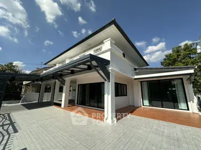 Stunning modern house with spacious patio and elegant design under clear blue sky.