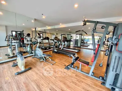 Modern gym with state-of-the-art equipment and mirrored walls in a luxury residential building.